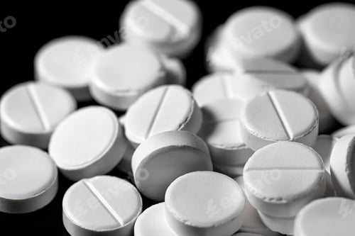 Preview: Close up of white painkiller tablet on a reflective black backgr