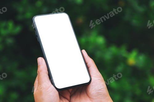 Preview: Hands holding black mobile phone with blank desktop screen with green nature background