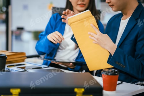Preview: A male and female lawyer are sitting at a desk in an office, discussing legal documents offering