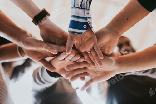 Preview: Group of diverse people stacking hands in the middle