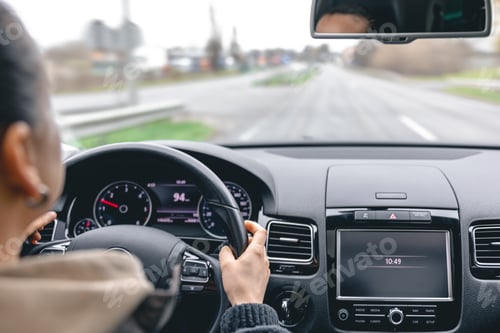 Preview: Woman driver's hands on a car steering wheel.