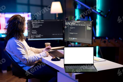 Preview: IT worker debugging code for software applications on mockup notebook