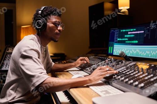 Preview: Young Adult Black Man Mixing Music Tracks in Professional Recording Studio