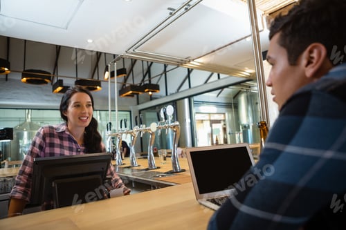 Preview: Female owner talking to customer at bar