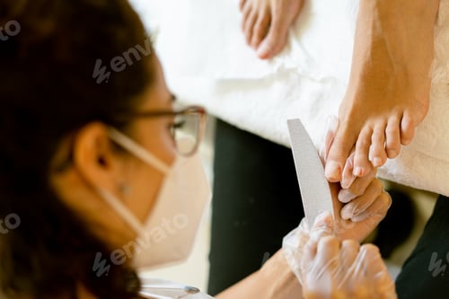 Preview: Beautician giving a pedicure painting her client's nails in a beauty centre. Business and beauty