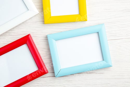Preview: Close up view of four empty picture frames in different colours on stripped background