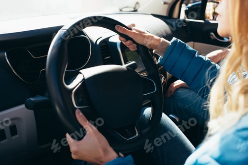 Preview: partial view of woman driving car with boyfriend near by, traveling concept