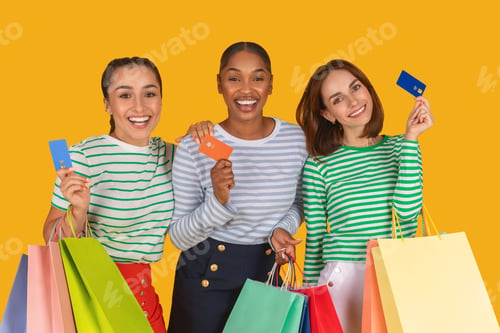 Preview: Multiracial women holding credit card and shopping bags
