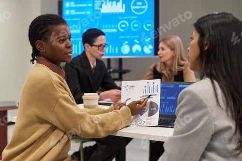 Preview: Young Black Woman Presenting Business Data to Colleague in Meeting