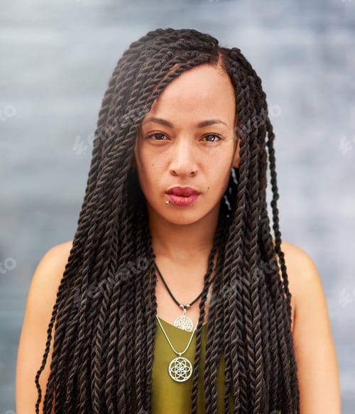 Preview: Portrait of an attractive young woman with beautiful braids posing outdoors