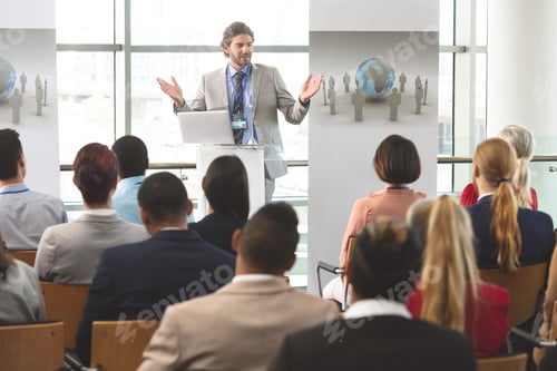 Preview: Businessman speaks in front of business colleagues at business seminar in office building