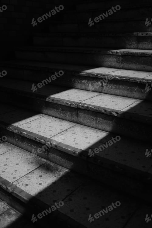 Preview: Grayscale vertical shot of stairs with sunlight shed on them