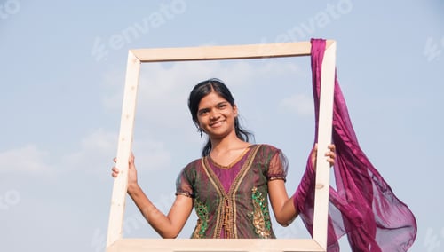 Preview: Young beautiful Indian girl with frame on nature background.