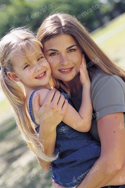 Preview: Mother and Daughter Embracing in a Green Field