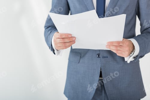 Preview: partial view of businessman holding papers in hands in office