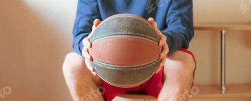 Visualização: jogador de basquete no vestiário no banco segurando a bola f