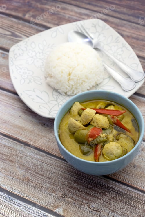 Preview: Green Curry With Fish Balls And Steamed Rice On A Wooden Table