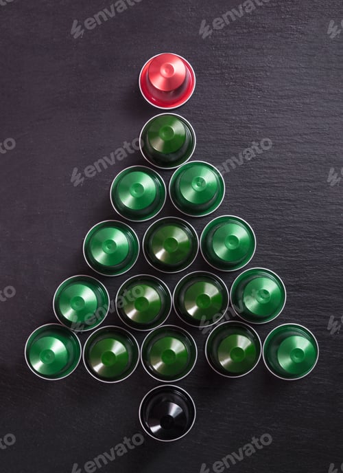 Preview: Espresso coffee pods christmas tree shape on black background, top view