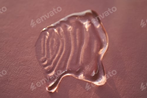 Preview: Beautiful volumetric drop of cosmetic product on a pink background.