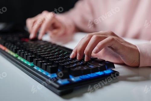 Preview: Hands of teenager over keys of computer keyboard typing while sitting by desk