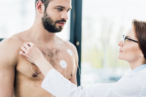 Preview: doctor putting electrodes on shirtless sportsman during endurance test