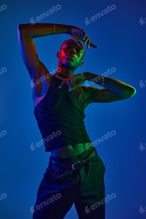 Preview: Young african american man showcases vibrant style in striking pose against colorful backdrop