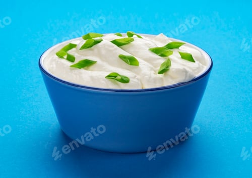 Preview: Bowl of sour cream on blue background