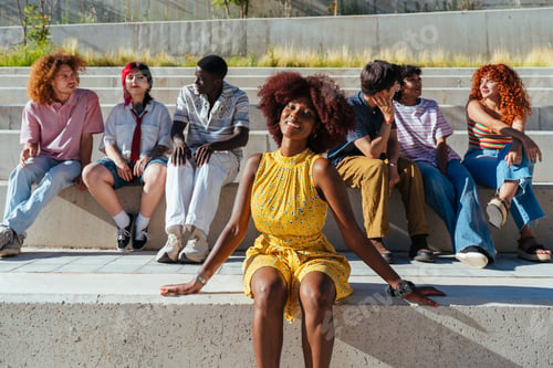Preview: Multiethnic group of young friends meeting and having fun outdoors