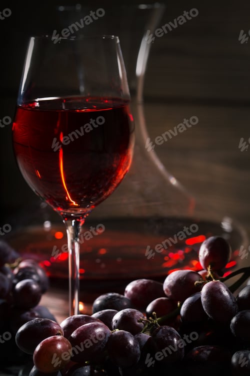 Preview: Glass of red wine and a bunch of grapes