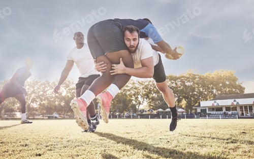 Preview: Caucasian rugby player attempting to tackle an opponent during a rugby match outside on the field.