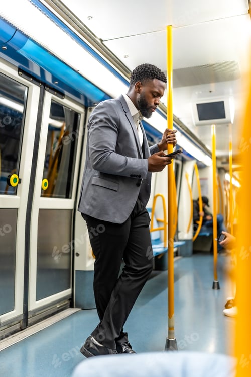 Preview: Elegant businessman using smartphone on subway train during commute
