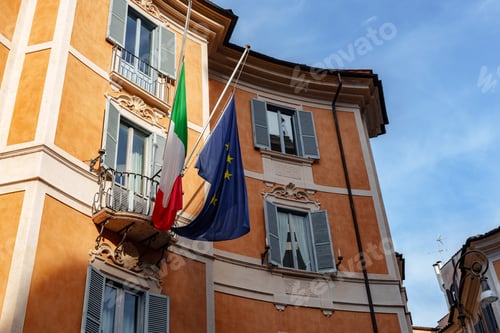 Preview: Italian flag and European Union flag wave from building balcony in Rome