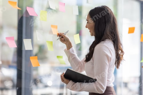 Preview: Business female employee with many conflicting priorities arranging sticky notes commenting and brai