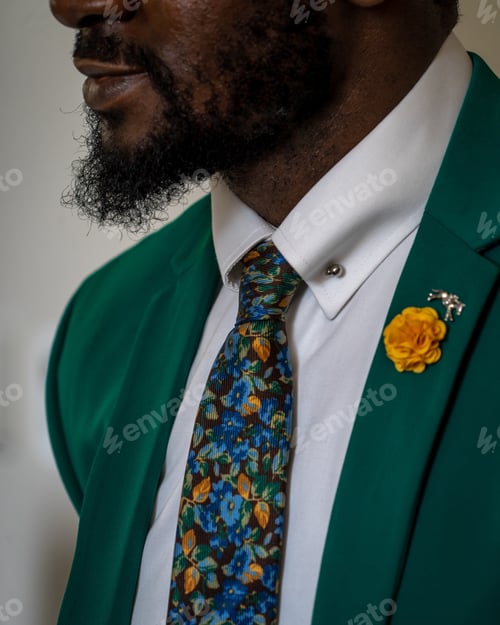 Preview: Vertical closeup shot of an African person with beard wearing gray suit with colorful tie