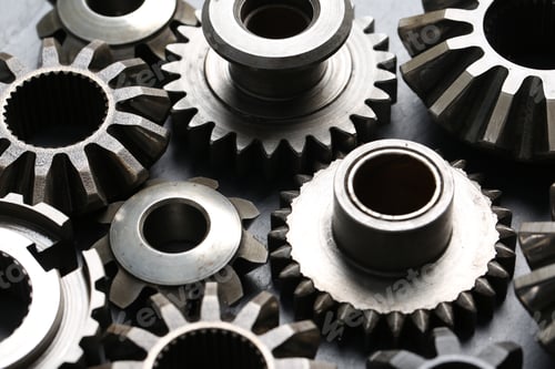 Preview: Many different stainless steel gears on grey background, closeup