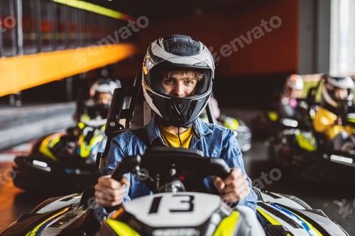 Preview: kart race close-up of concentrated boy in cart with helmet before starting race,