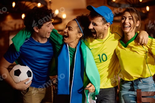 Preview: Excited sports fans shouting out of joy while watching match in a pub.