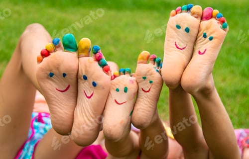 Preview: Children's feet painted on the grass. Selective focus.