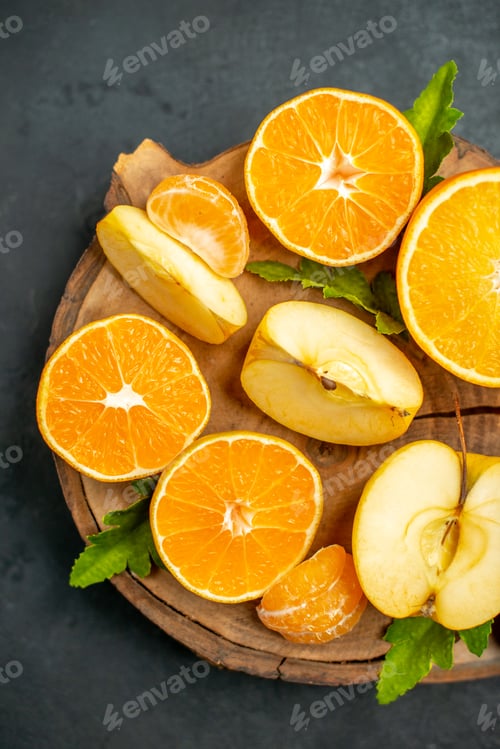 Preview: top view cut oranges and apples cut orange on dark background
