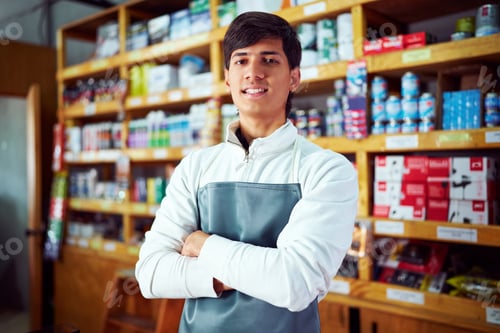 Preview: Confident salesperson smiling with arms crossed in hardware store