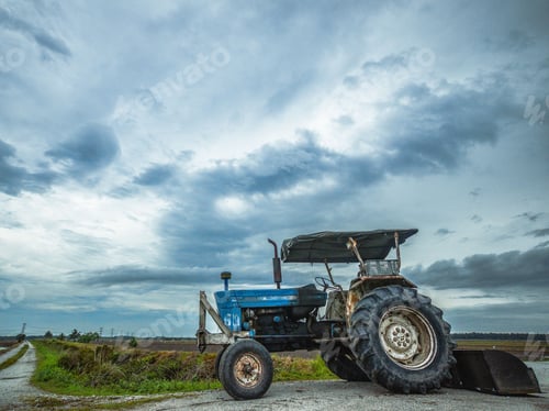 Preview: Old tractor parked in a rural area, surrounded by an open field.