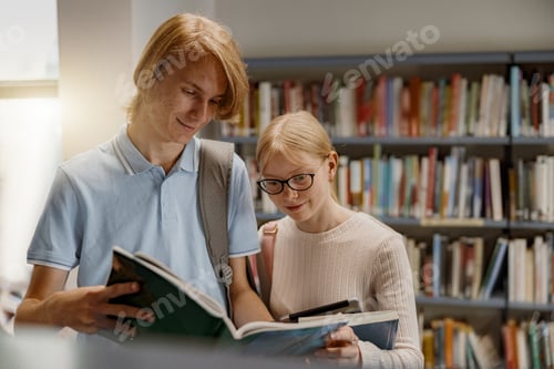 Preview: Two friends student chooses books while standing in the university library . Education concept