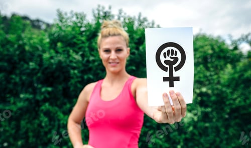 Preview: Blonde Woman Holds Feminism Symbol Outdoors