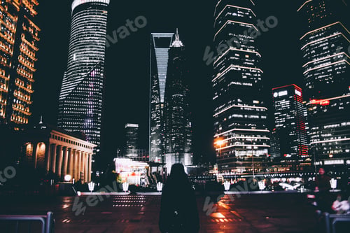 Preview: Millenial woman surrounded by skyscrapers in Shanghai.