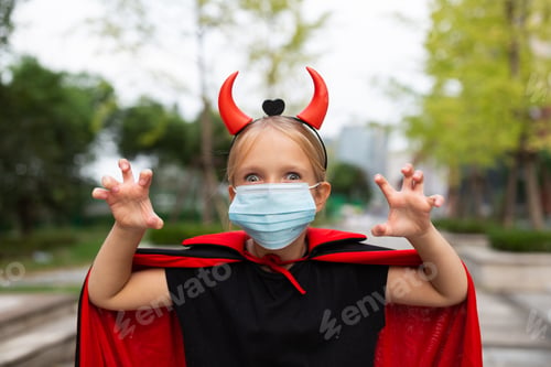 Preview: Portrait of cute Little Girl in costume of evil in park. Happy Halloween during coronavirus covid-19