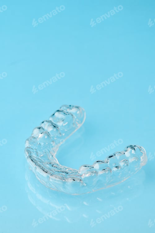 Preview: Close up invisible aligners on the blue background with copy space. Plastic braces dentistry