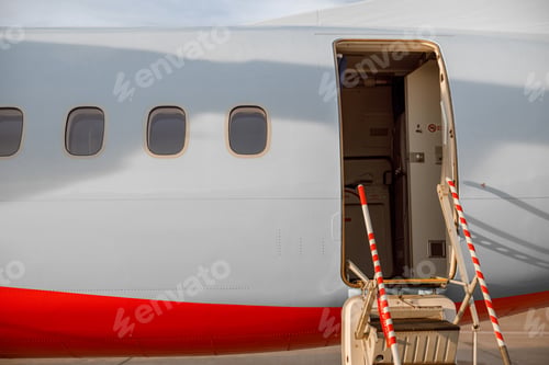 Preview: Passenger airplane with open entrance door at airport