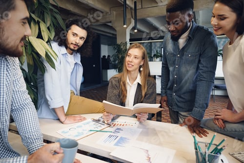 Preview: Team of diverse coworkers in modern office discuss their project together