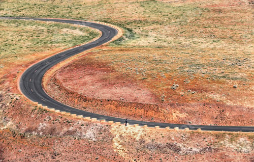 Preview: A curving country road winding through a scrubland, seen from above.