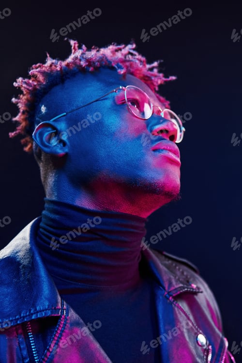 Preview: In glasses. Futuristic neon lighting. Young african american man in the studio